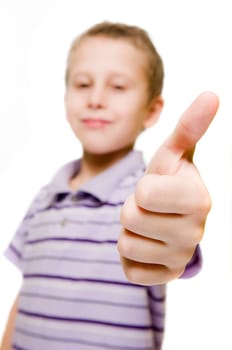 Upper body view of a seven-year-old boy against a white background showing his thumbs up