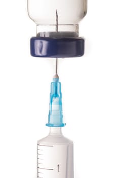 Syringe, needle and medicine vial. The needle sticks through the sterile membrane into the clear liquid.