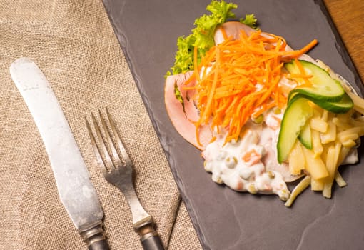 Danish specialties and national dishes, high-quality open sandwich. Sandwich with sliced ham, Mayonnaise with green peas and carrot tart, cracked carrots, asparagus and cucumbers