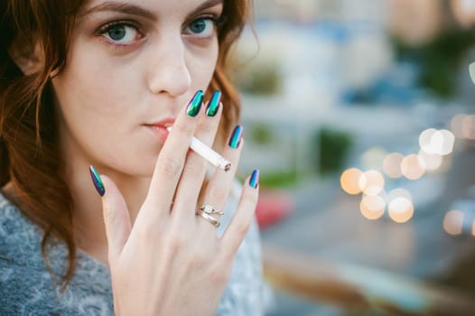 girl with a cigarette. young beautiful woman smokes a cigarette in the street