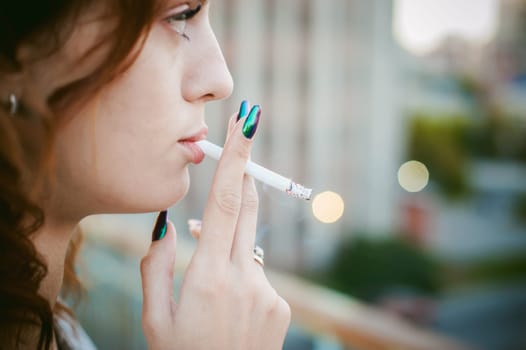 girl with a cigarette. young beautiful woman smokes a cigarette in the street