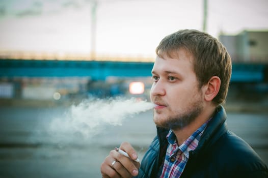cigarette smoking. a man with a beard smokes a cigarette on the street in a public place.