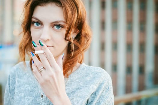 girl with a cigarette. young beautiful woman smokes a cigarette in the street