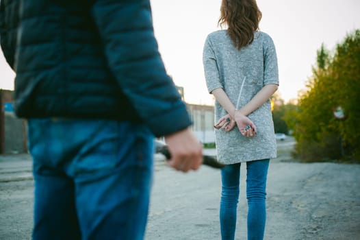 a guy with a knife chasing a girl. Man with a gun in his hand catches up with the young wife of connectedness with hands behind his back.