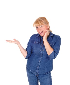 A beautiful blond woman standing waist up in a jeans jacket and pants.pointing with her hand, isolated for white background..