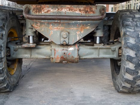 Detailed view of the front axle of a used excavator chassis.
