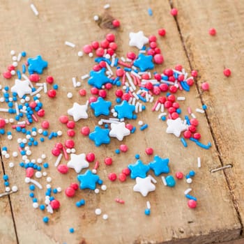 Colorful sugar sprinkles in red,white and blue on a rustic wooden background