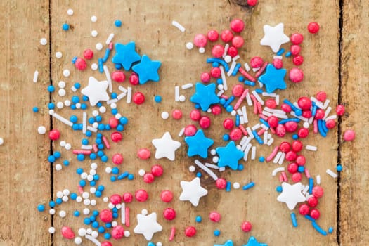 Colorful sugar sprinkles in red,white and blue on a rustic wooden background
