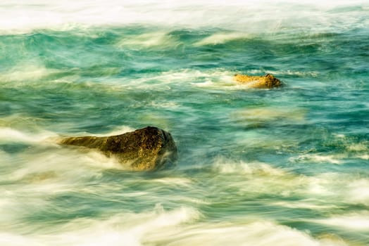 Surf of the Atlantic Ocean with rocks in long exposure