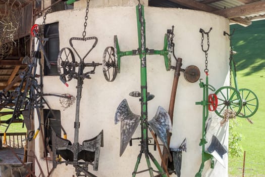many agricultural tools hanging on barn wall farm