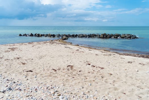 small sea barrier made of stones at the north side of sealand, denmark