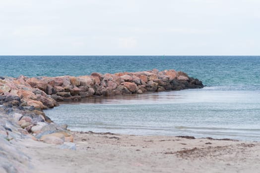 small sea barrier made of stones at the north side of sealand, denmark