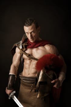 Ancient warrior or Gladiator posing over a dark background