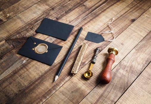 Blank stationery elements on vintage wooden table background.