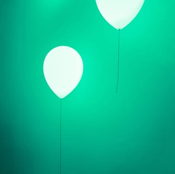 Balloon shape lamp illuminated on green wall background