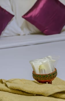 Shower set and yellow towel on bed sheet linen