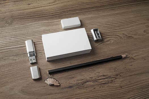 Bank business cards, pencil, eraser, flash drive and sharpener on wooden table background. Template for placing your design. Mockup for ID.