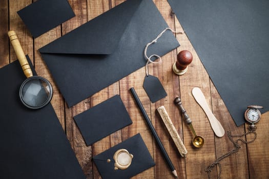 Blank black corporate identity set on wooden table background. Branding mock up. Black stationery elements. Blank objects for placing your design.