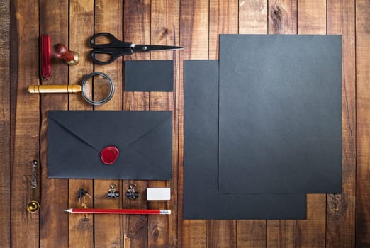 Photo of blank corporate identity. Black stationery set on vintage wood background. Branding mockup. Blank objects for placing your design. Top view.