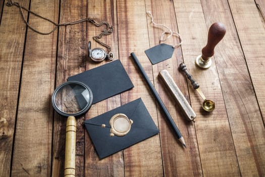 Blank stationery elements on vintage wood table background.