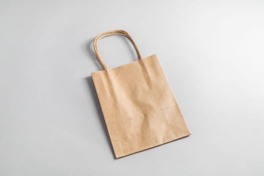 Recycled paper shopping bag on paper background. Craft paper package.
