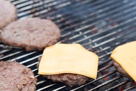 Hamburger Patties on Barbecue with cheese.