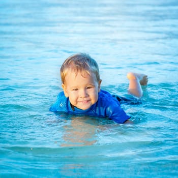 Cute boy plays in a sea