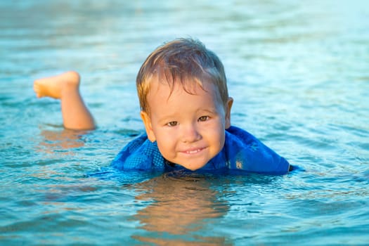 Cute boy plays in a sea