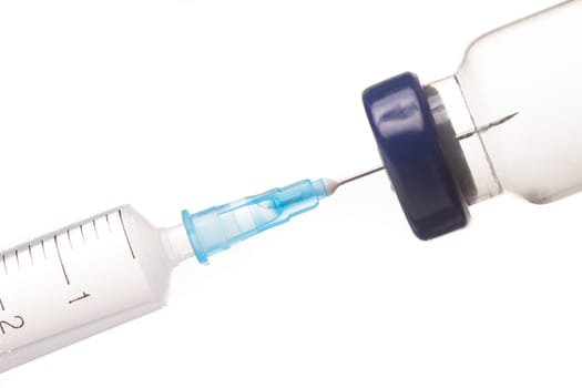 Syringe, needle and medicine vial. The needle sticks through the sterile membrane into the clear liquid.