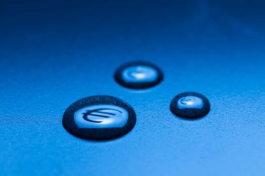 Three liquid drops with mirrored EURO symbol on a blue background with gradient.
