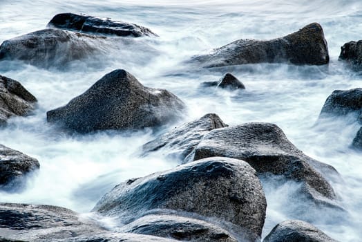 Surf of the Atlantic Ocean with rocks in long exposure