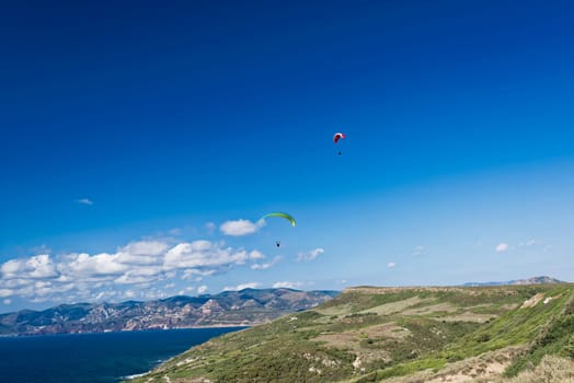 Colorful hang glider in sky over blue sea