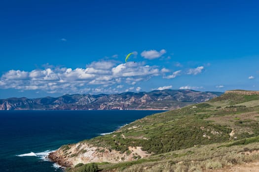 Colorful hang glider in sky over blue sea