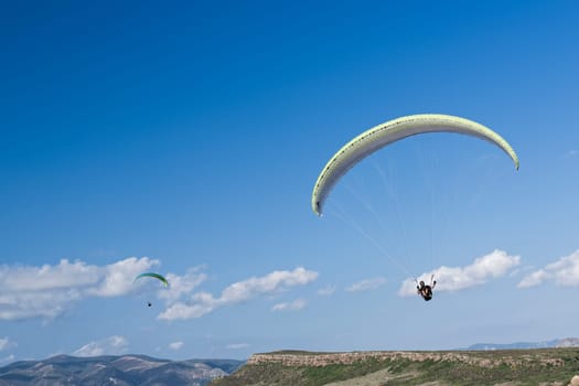 Colorful hang glider in sky over blue