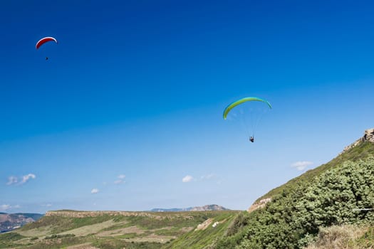 Colorful hang glider in sky over blue sea