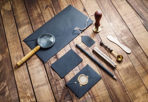 Blank black vintage stationery elements on wood table background. Responsive design mockup. ID template.