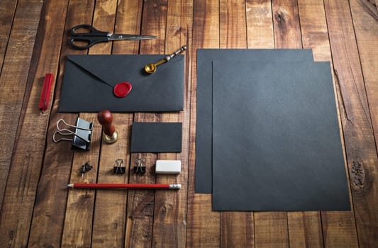 Black stationery mock up. Blank paperwork template for designers. Responsive design mockup on vintage wooden table background.