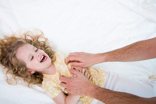 father tickling his daughter