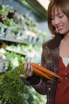 Young woman holding a bunch of carrots