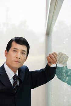 Japanese businessman leaning on a window