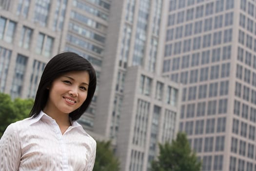 Smiling businesswoman near an office building