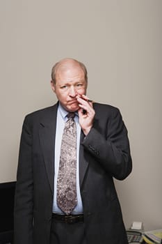 Mature businessman chewing his pen