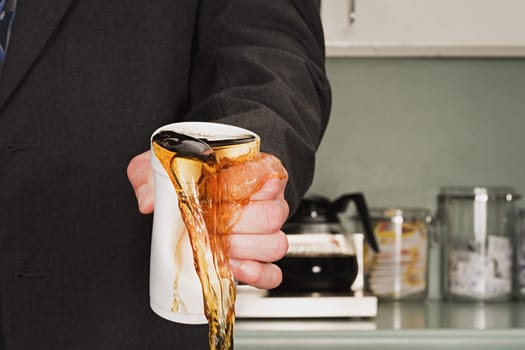 Businessman crushing coffee cup