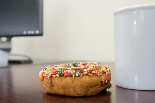 Coffee cup and doughnut on desk