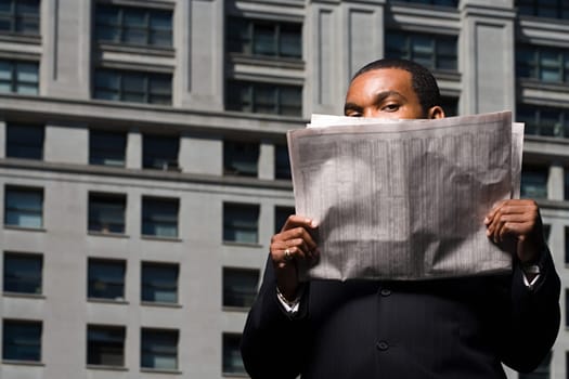 Businessman looking over newspaper