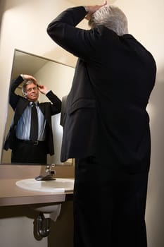 Man combing his hair in mirror