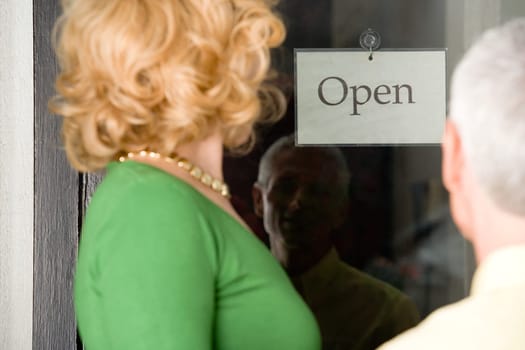 Couple looking at sign in shop window