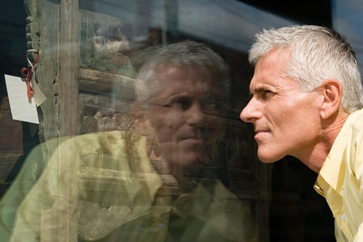 Man looking at dresser in shop window