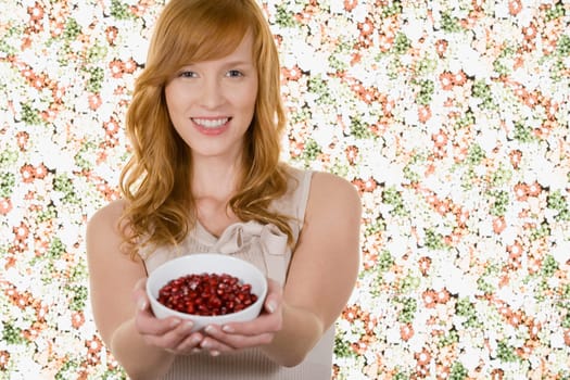 Woman holding bowl of pomegranate seeds
