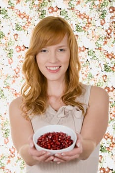 Woman holding bowl of pomegranate seeds